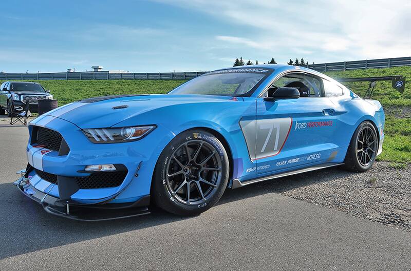 A side view of a blue Mustang on display with the number 71 on the side