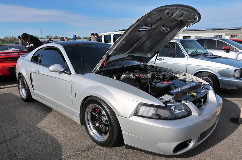 A silver Mustang on display with the hood up