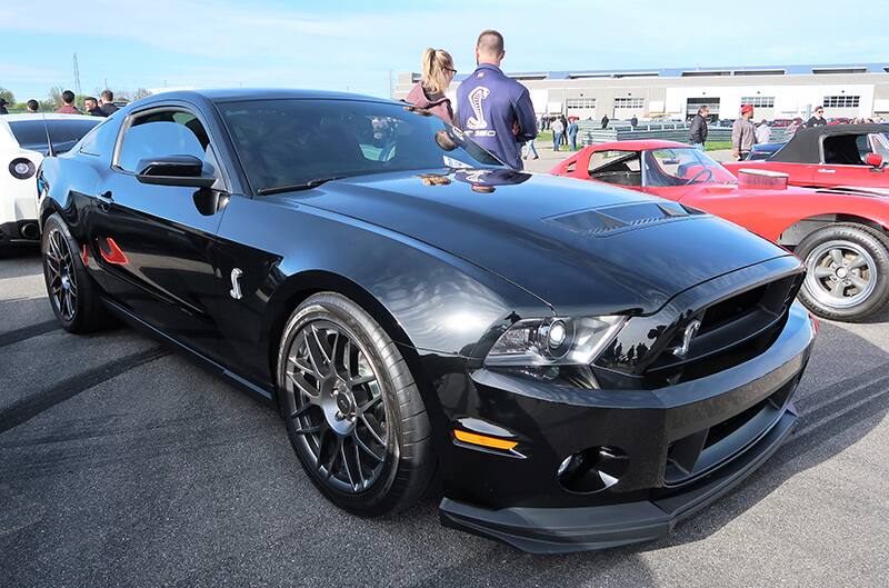 A front side view of a black Ford Mustang on display