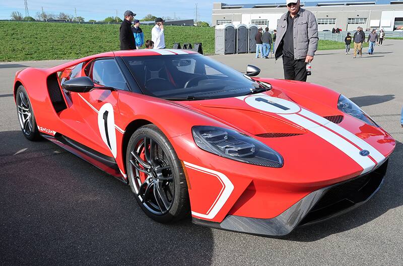 A front side view of a red and white Ford GT on display