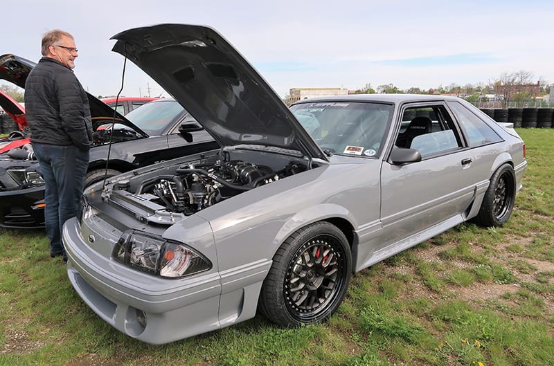 A front side view of a grey Ford vehicle on display with the hood up