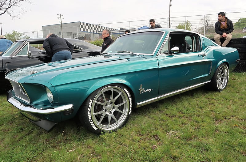 A front side view of a classic green Mustang on display