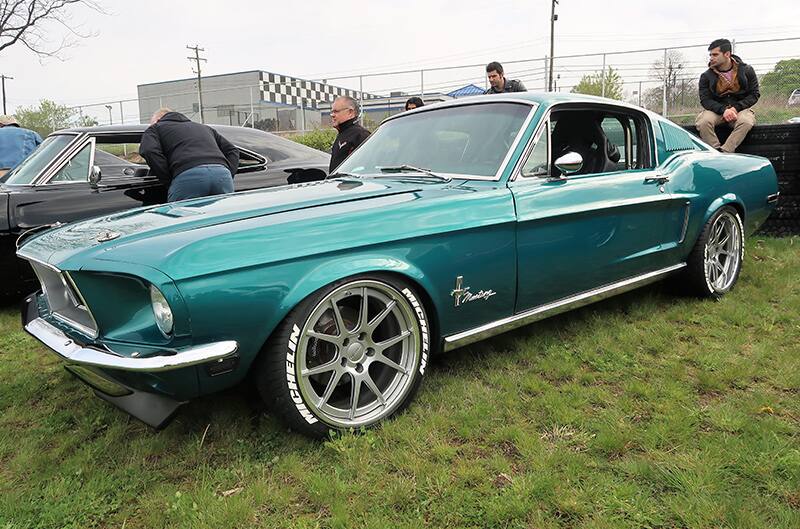 A front side view of a classic green Mustang on display