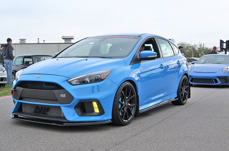 A light blue Ford Focus RS driving down the road