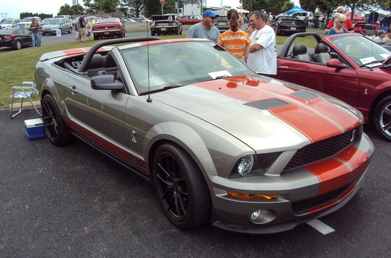 Front profile of a silver Shelby GT with red stripes in the parking lot