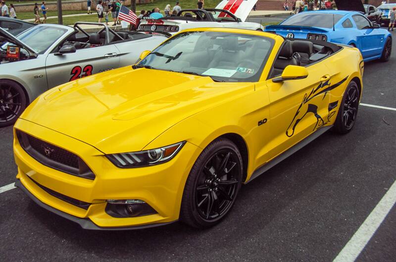 Front profile of a yellow Mustang in the parking lot