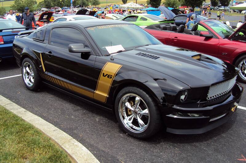 Front profile of a black Mustang V6 in the parking lot