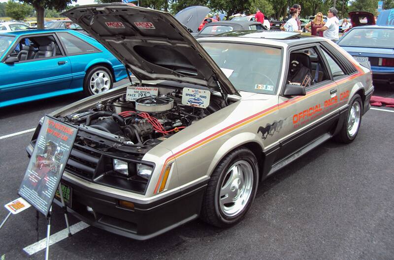 Front profile of a silver Mustang official pace car with hood open in the parking lot