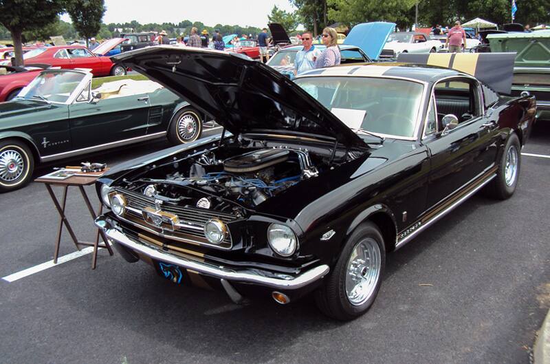 Front of a black Mustang with hood open in the parking lot