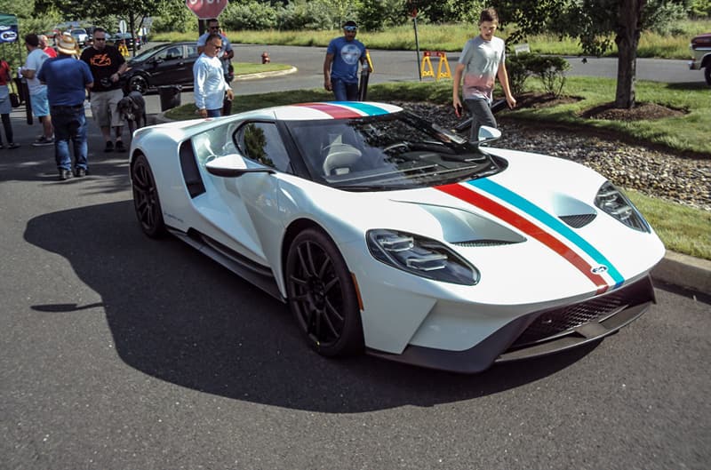 Front of a white GT with red and green stripes in parking lot