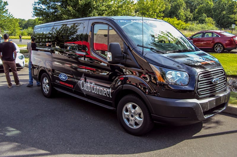 Front profile of a black Ford Performance Club Connect transit van in parking lot