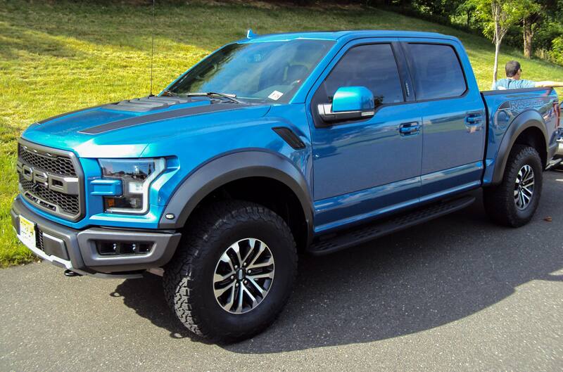 Front profile of a blue Raptor in parking lot