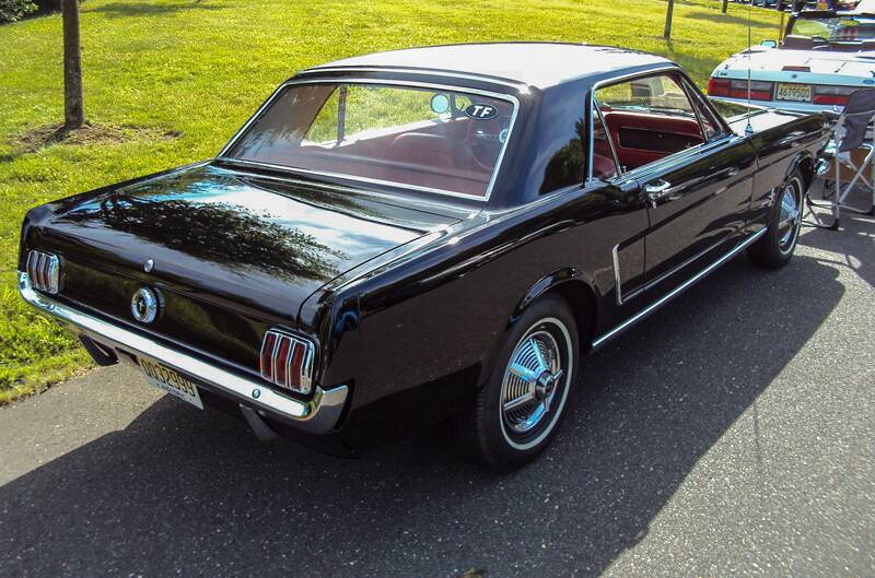 Rear profile of a black Mustang in the parking lot