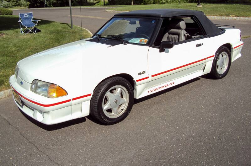 Front profile of a white Mustang GT in the parking lot