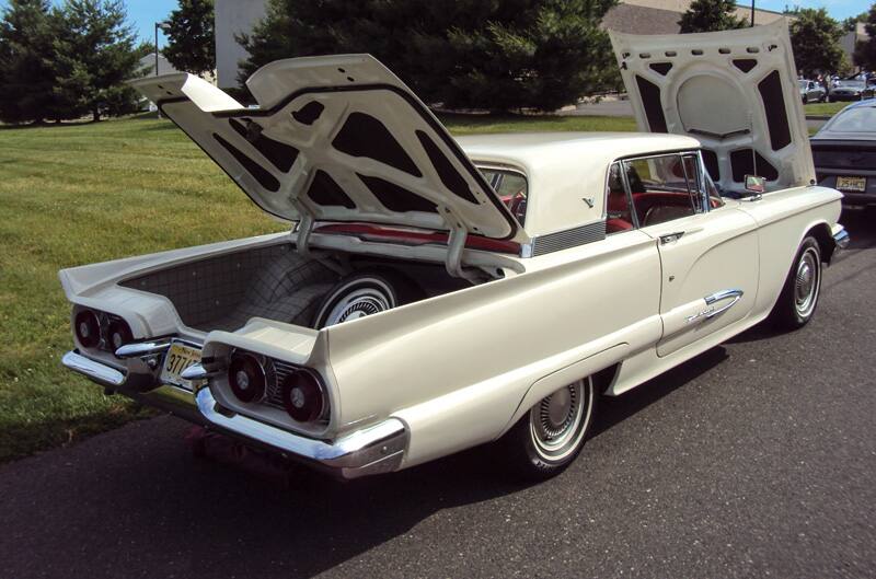 Rear profile of a white Thunderbird with trunk and hood open in parking lot