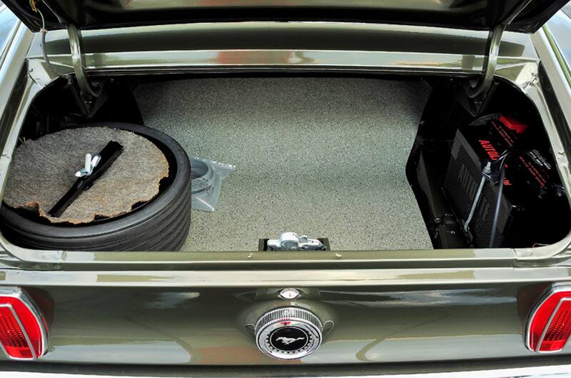 Close up interior of open trunk with spare tire and car part inside