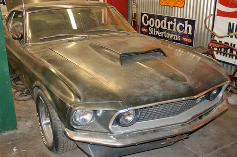 Close up front of dusted black Mustang Boss 429 in garage