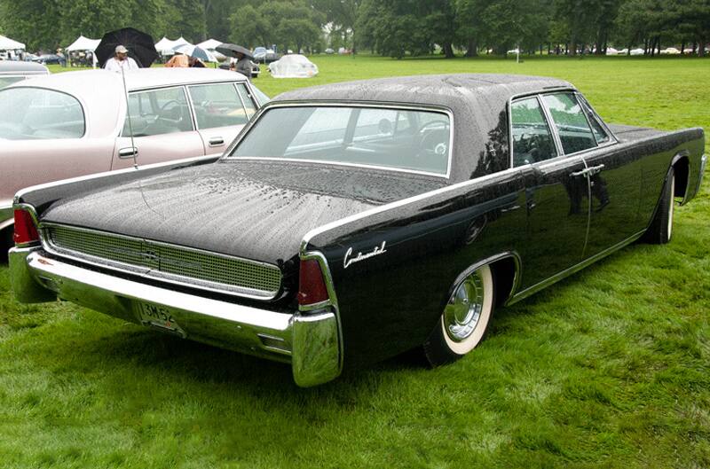 A rear side view of a black Lincoln Continental on display