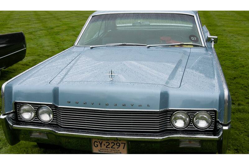 A front end view of a classic light blue Lincoln Continental on display