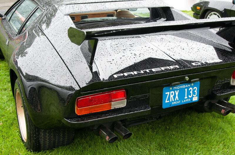 A rear side view of a black Pantera on display