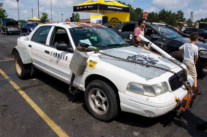 An old police car on display with chains on the hood