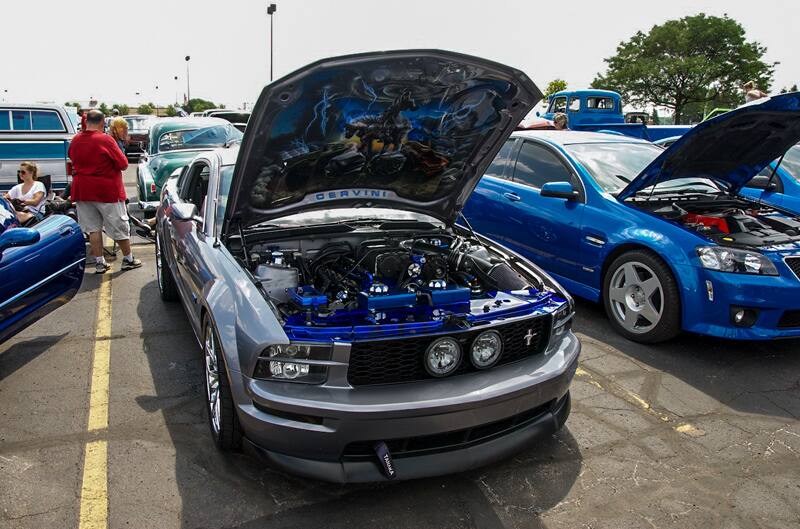 A grey Mustang on display with a drawing on the bottom of the hood