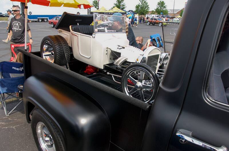 A front side view of a classic vehicle on display on a trailer