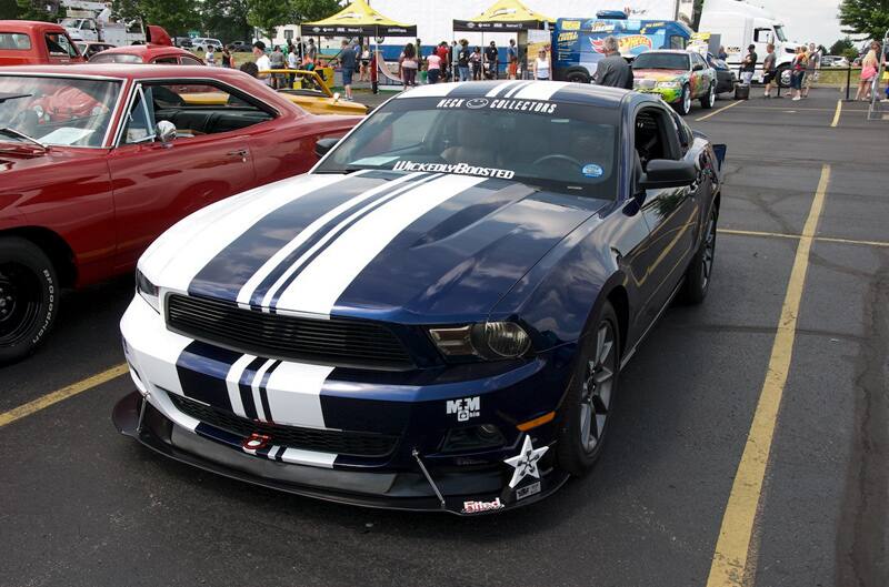 A front side view of a blue and white Mustang on display