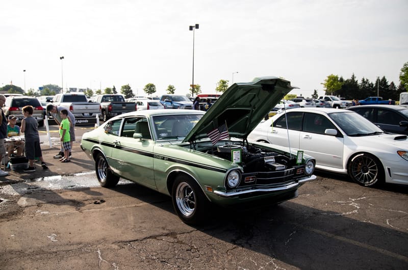 A front side view of a classic green Mustang on display