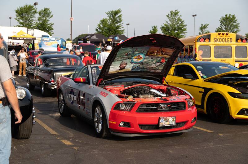 A silver and red Mustang on display with the hood up and the number 44 on the side