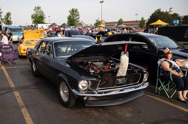 A front side view of a classic black Mustang on display