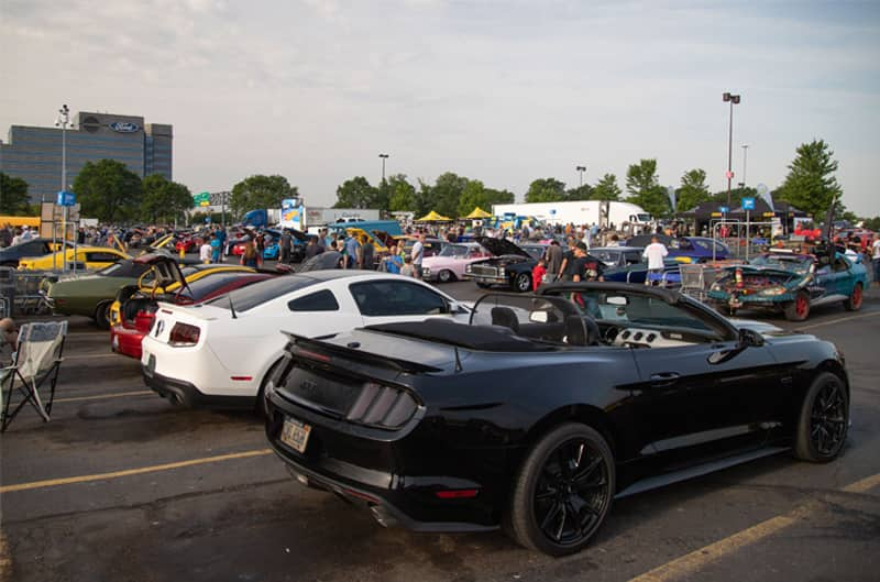 A rear side view of a black Mustang convertible on display