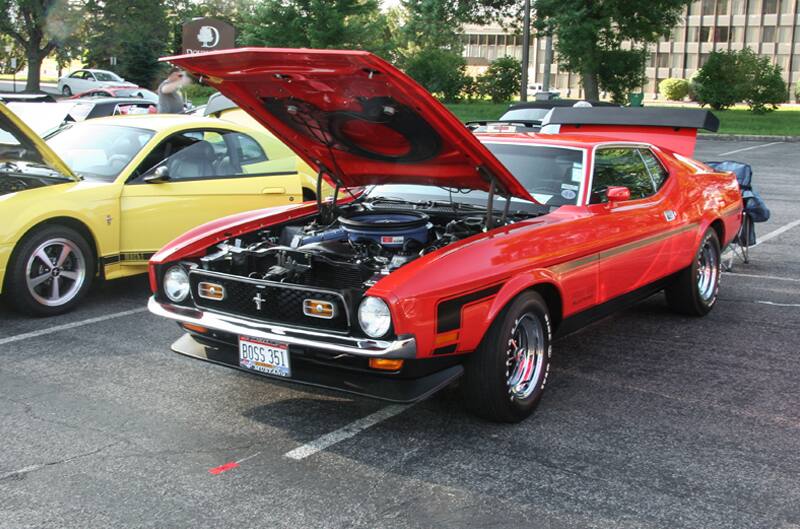 A front side view of a classic red Mustang on display