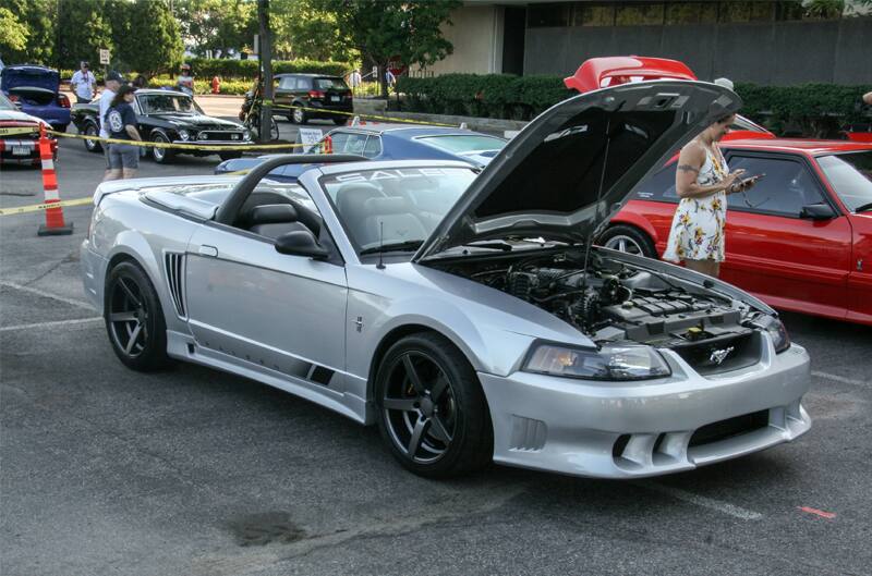 A front side view of a silver Mustang on display