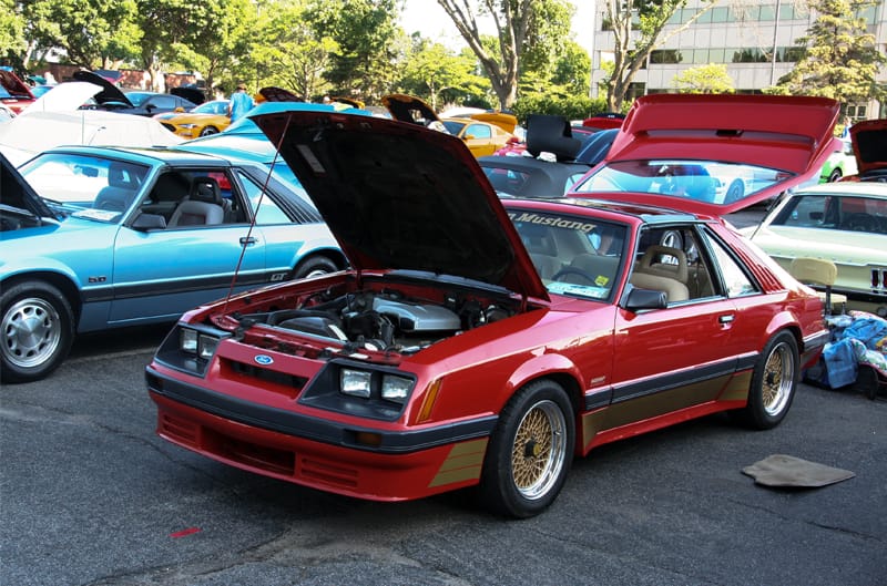 A red Ford vehicle with the hood and trunk open