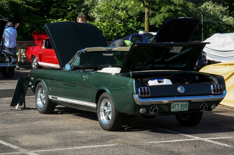 A rear side view of a green Mustang on display