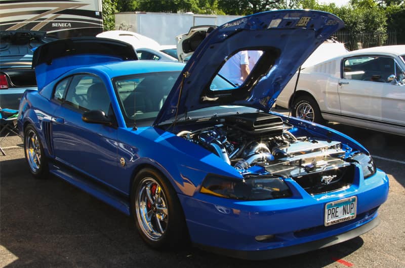 A blue Mustang on display with the hood and trunk open