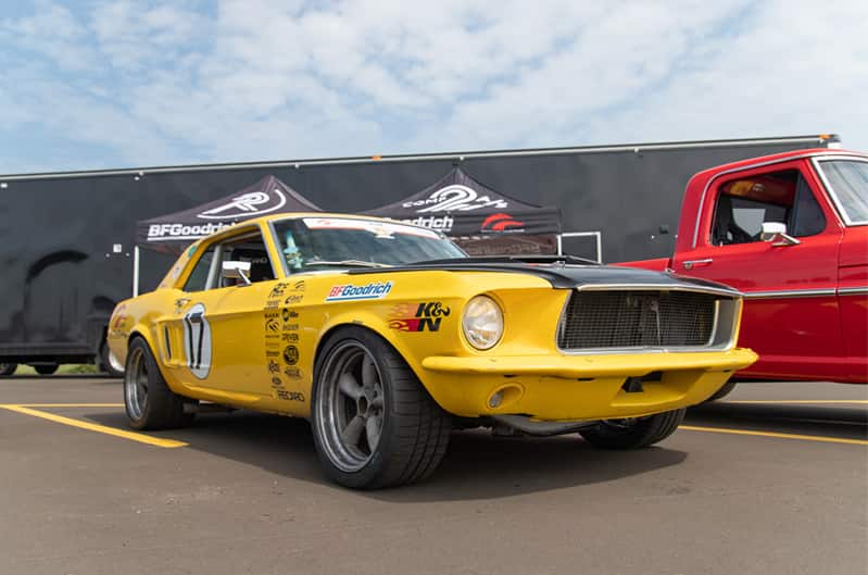 A front side view of a classic yellow Mustang on display