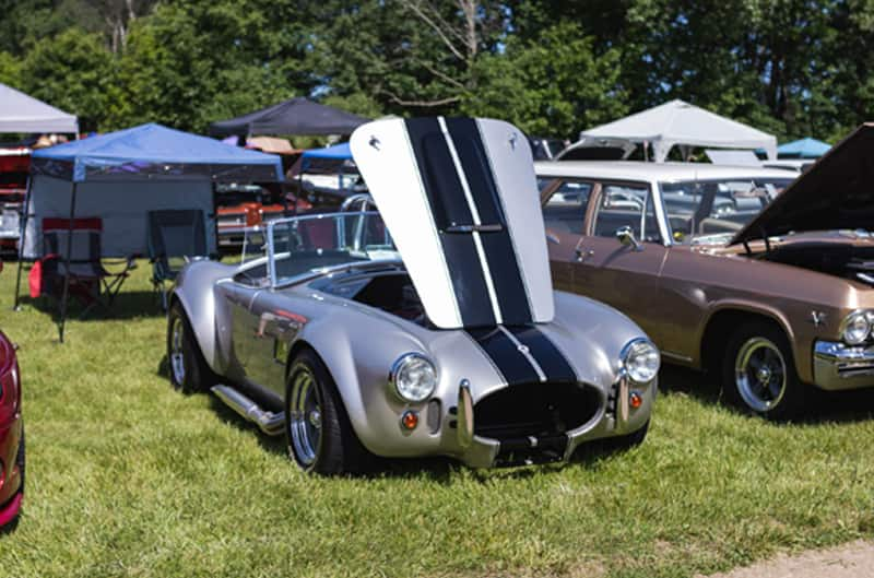 A classic silver vehicle on display with the hood up