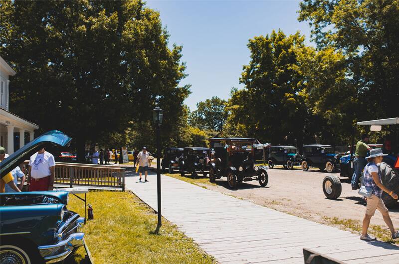 A look at people admiring and driving classic Ford vehicles