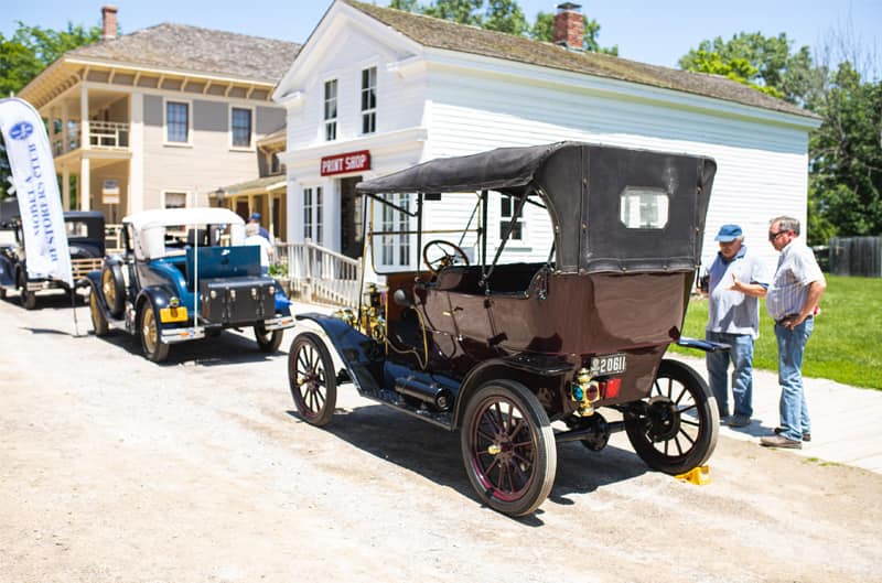 Two people admiring a classi vehicle on display