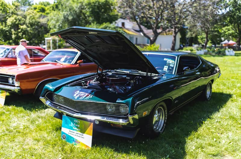 A front side view of a classic green Mustang on display