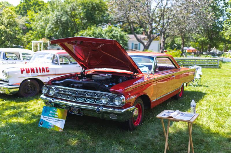 A classic red vehicle on display with the hood up