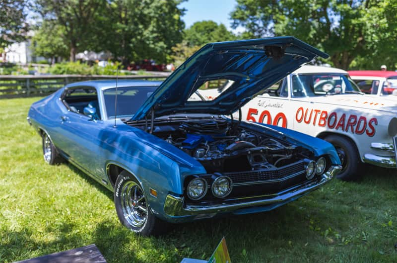 A classic blue vehicle on display with the hood up