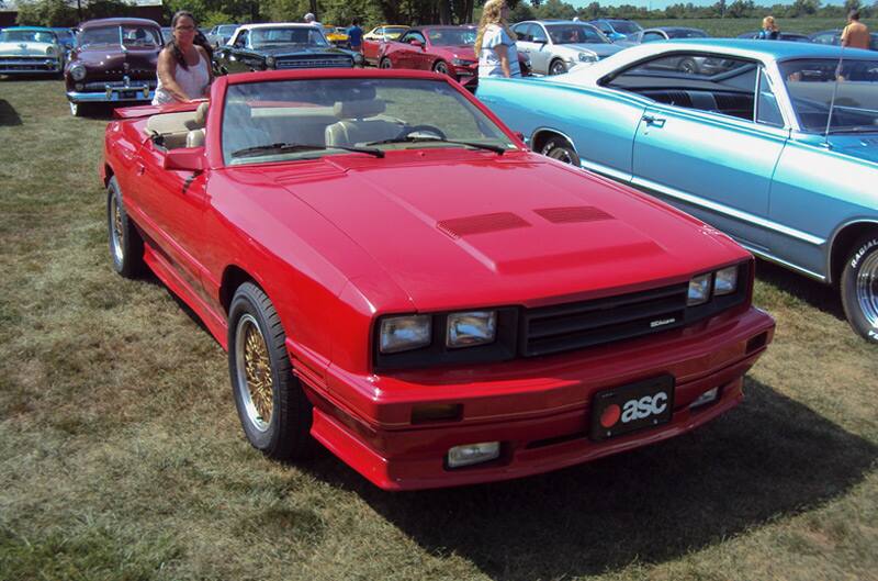 Front of a red Mustang convertible parked on the grass