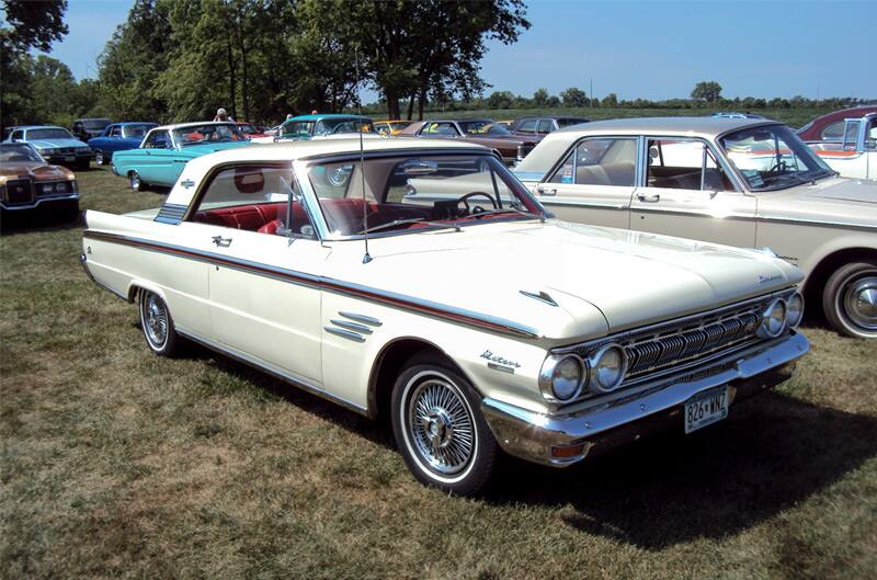 Front profile of a white Mercury parked on the grass