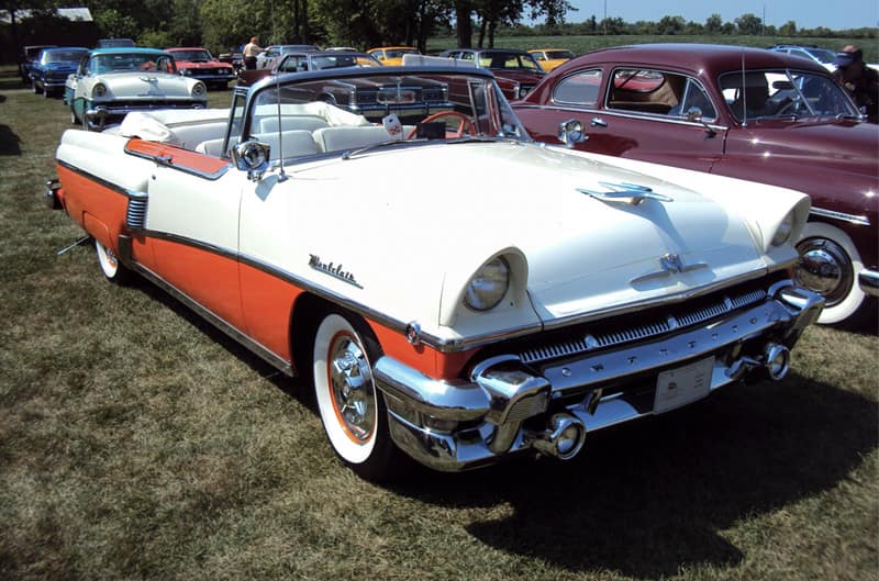 Front profile of a white and orange Pontiac Star Chief Convertible parked on the grass