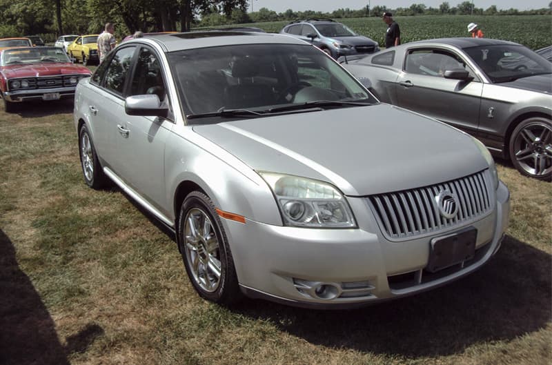 Front profile of a silver Mercury parked on the grass