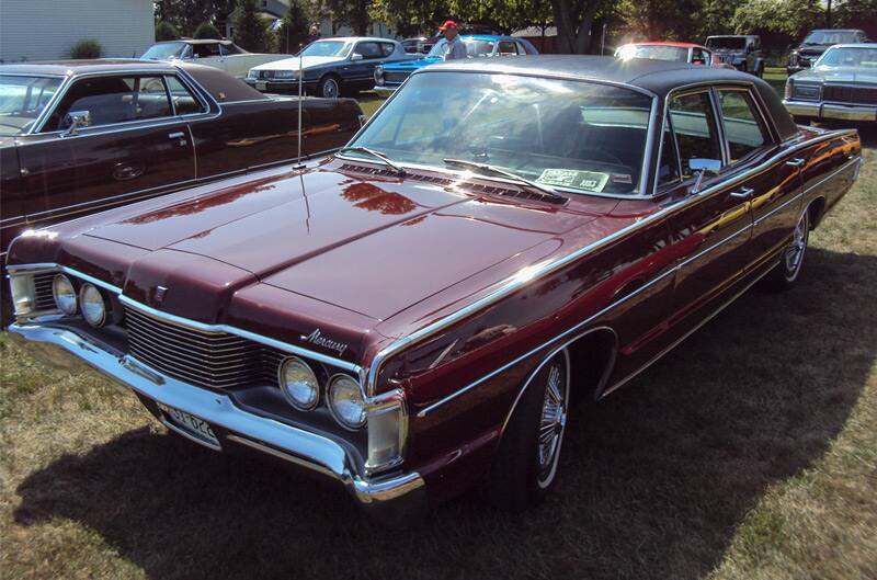 Front of a red Mercury parked on the grass