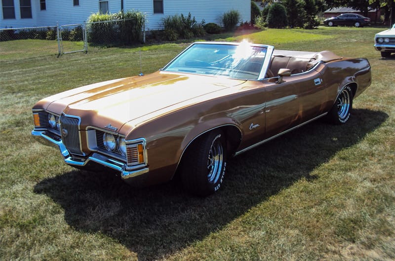 Front profile of a gold Mercury convertible parked on the grass